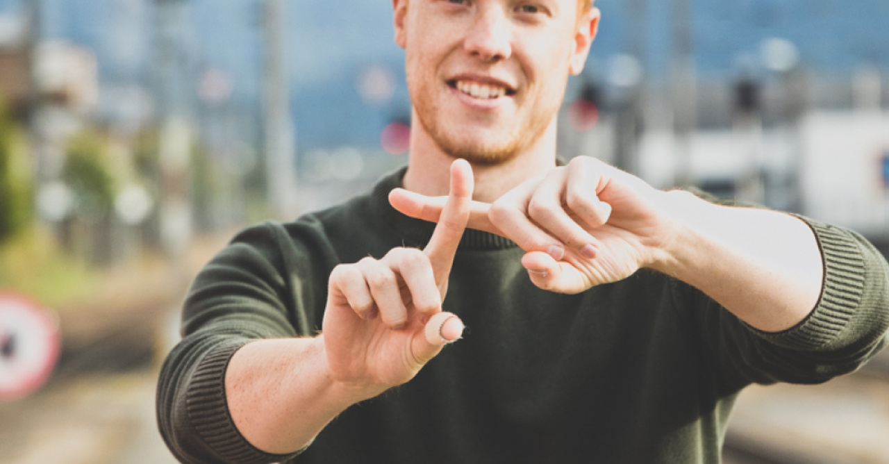 Mann, der ein Plus-Symbol zeigt