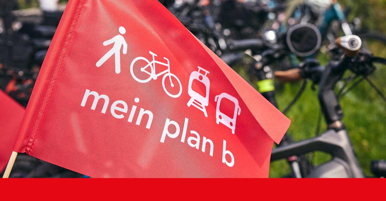 Rote plan b-Fahne im Vordergrund, im Hintergrund unscharf Fahrräder