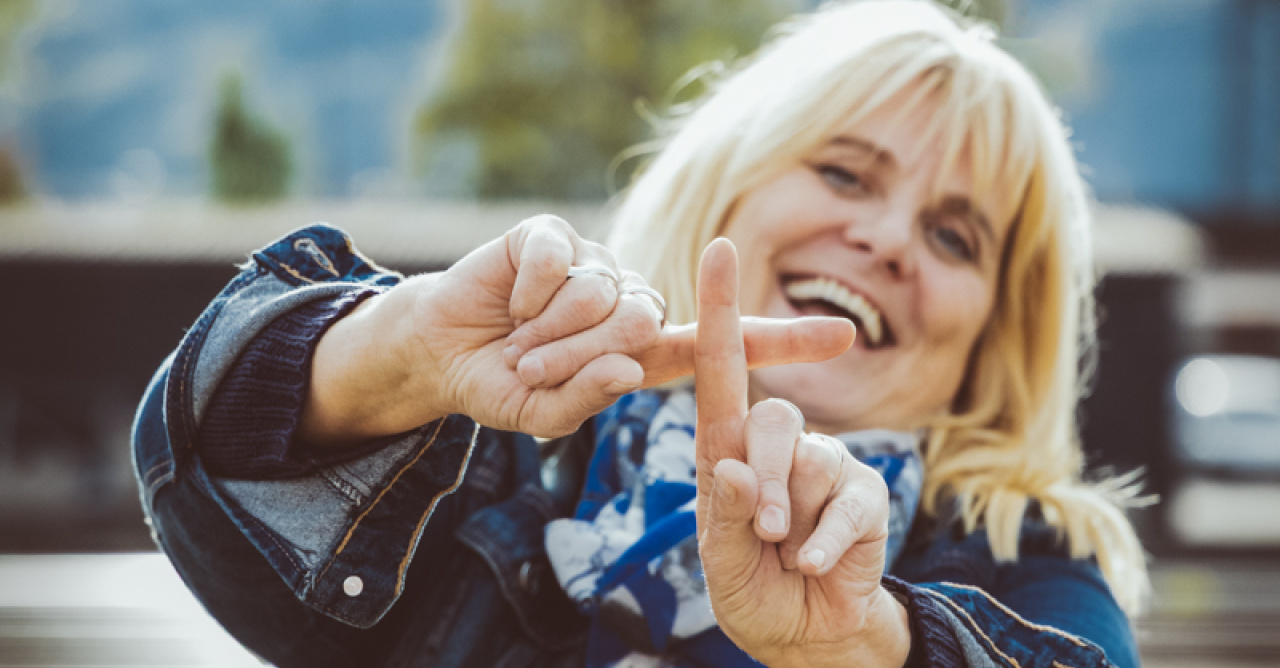Frau formt mit ihren Zeigefingern ein Plus
