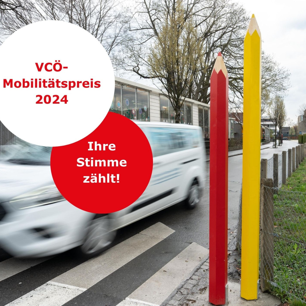 Auto fährt an den großen plan b-Buntstiften vor einer Schule vorbei. 