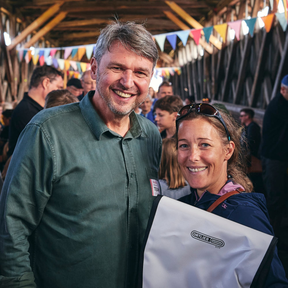 Bürgermeister Kurt Fischer übergibt beim Rad-Ried-Tag in der alten Senderbrücke einer glücklichen Gewinnerin der Verlosung Ihren Preis