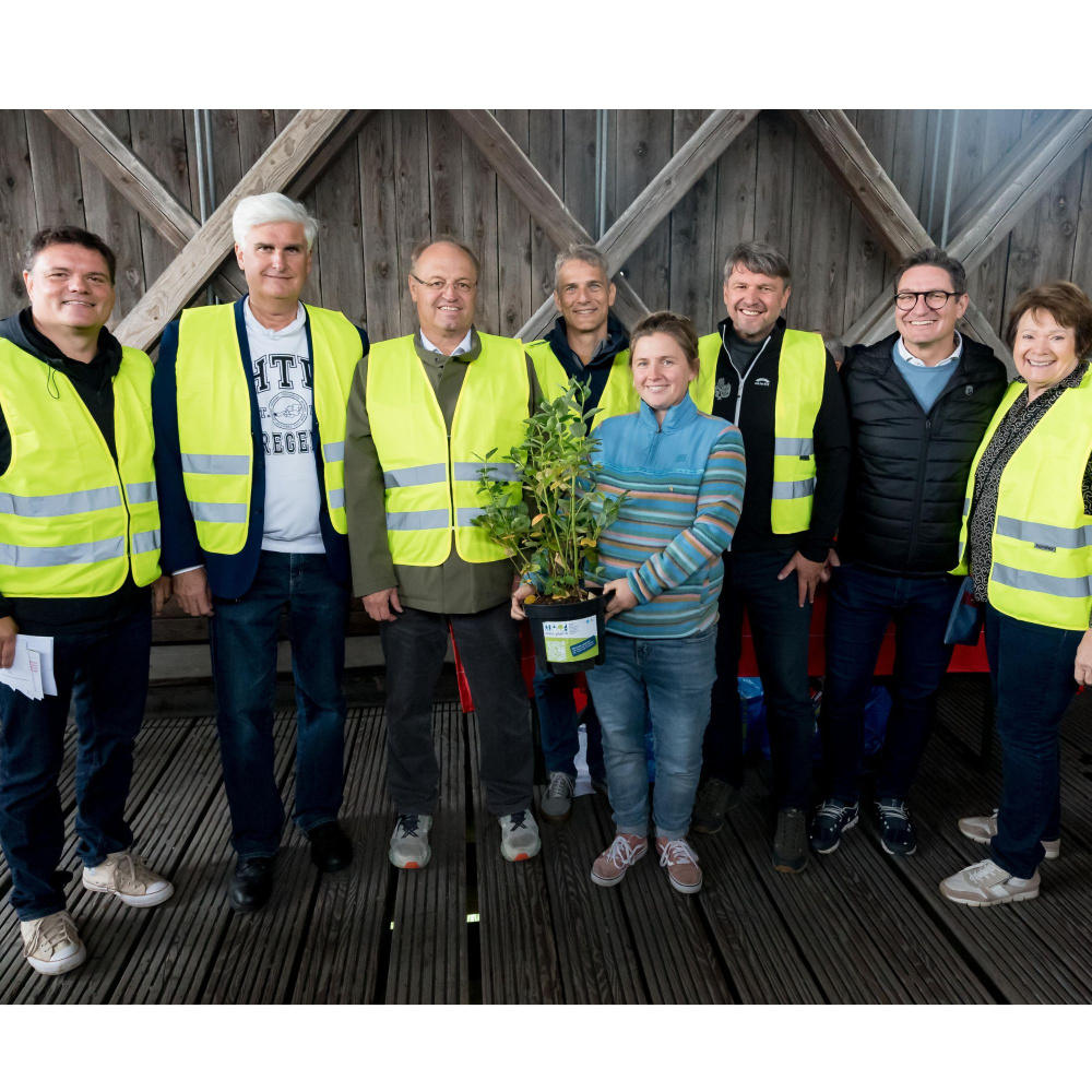 Gruppenfoto der Vertreter:innen der plan b-Gemeinden bei der Übergabe des Apfelbaums als Symbol für die Aktion "Radkilometer wachsen lassen"