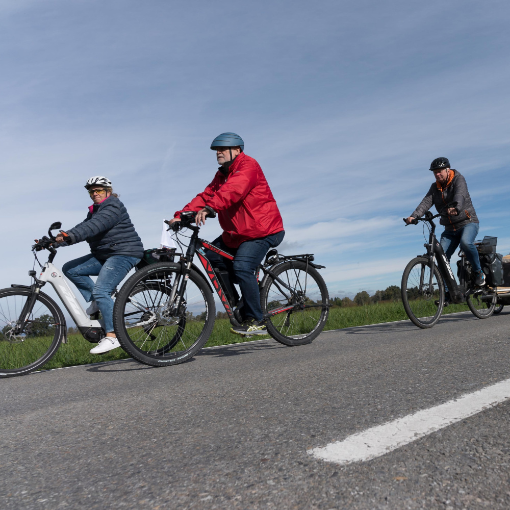 Menschen auf Fahrrädern unterwegs auf den autofreien Straßen im Ried bei schönem Herbstwetter