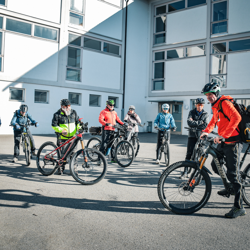 Teilnehmer:innen des Radpat:innen-Kurses stehen mit Ihrem Fahrrad beim asphaltierten Übungsplatz