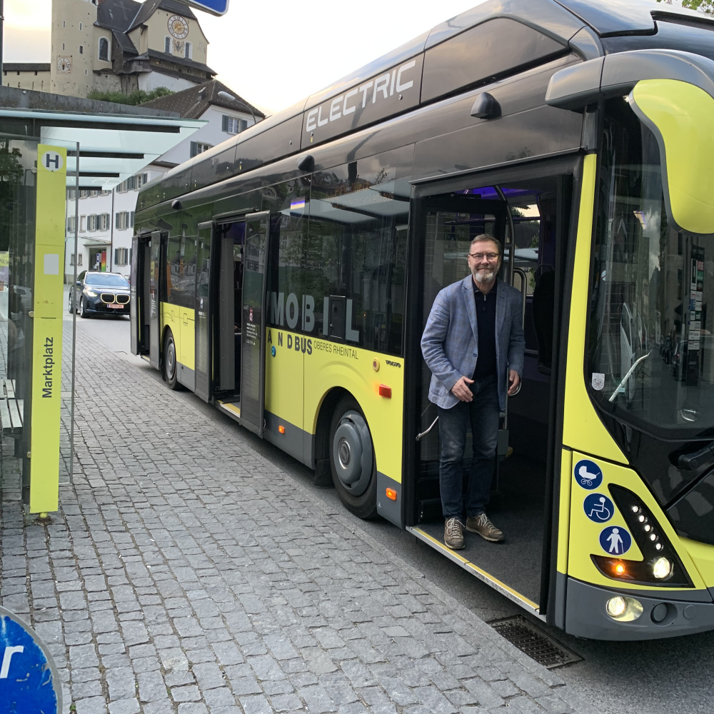 Norbert Wanker steht in der vorderen Bus-Einstiegstüre und lächelt in die Kamera