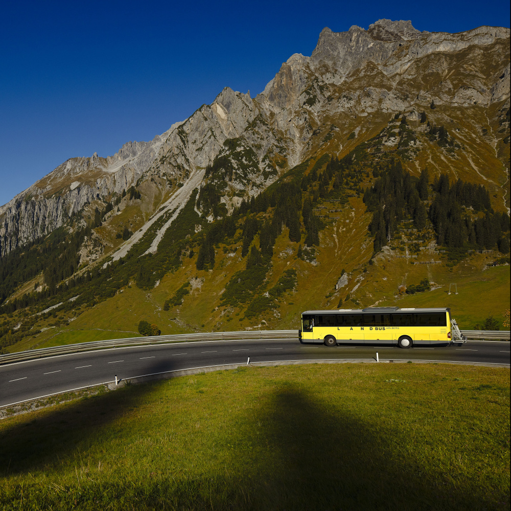 Ein Landbus fährt auf einer Bergstraße. 