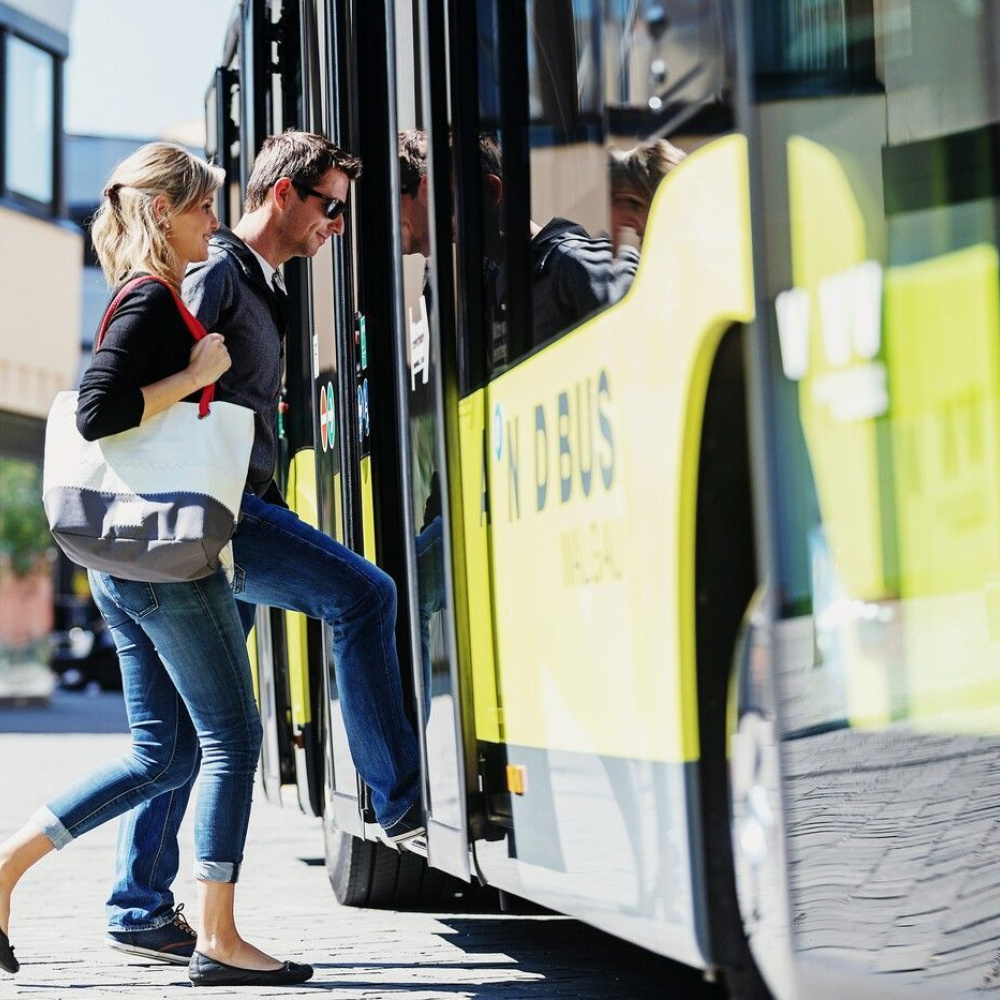 eine Dame und ein Herr die in den Bus einsteigen
