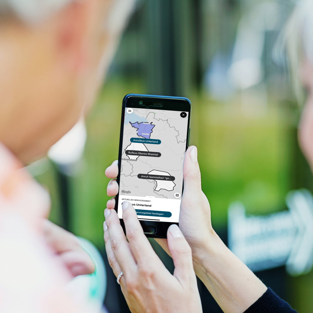 Zwei Personen blicken auf ein Handy mit der VMOBIL On App
