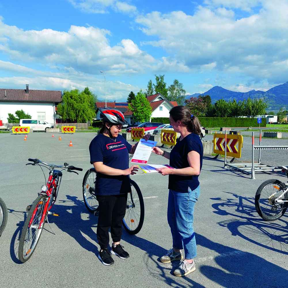 Das Zertifikat zur Teilnahme am Frauenfahrradkurs wird an eine Teilnehmerin übergeben