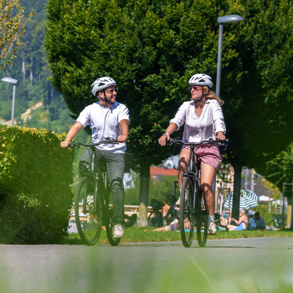 Ein Mann und eine Frau sind gemeinsam mit dem Fahrrad auf dem Radweg unterwegs. 