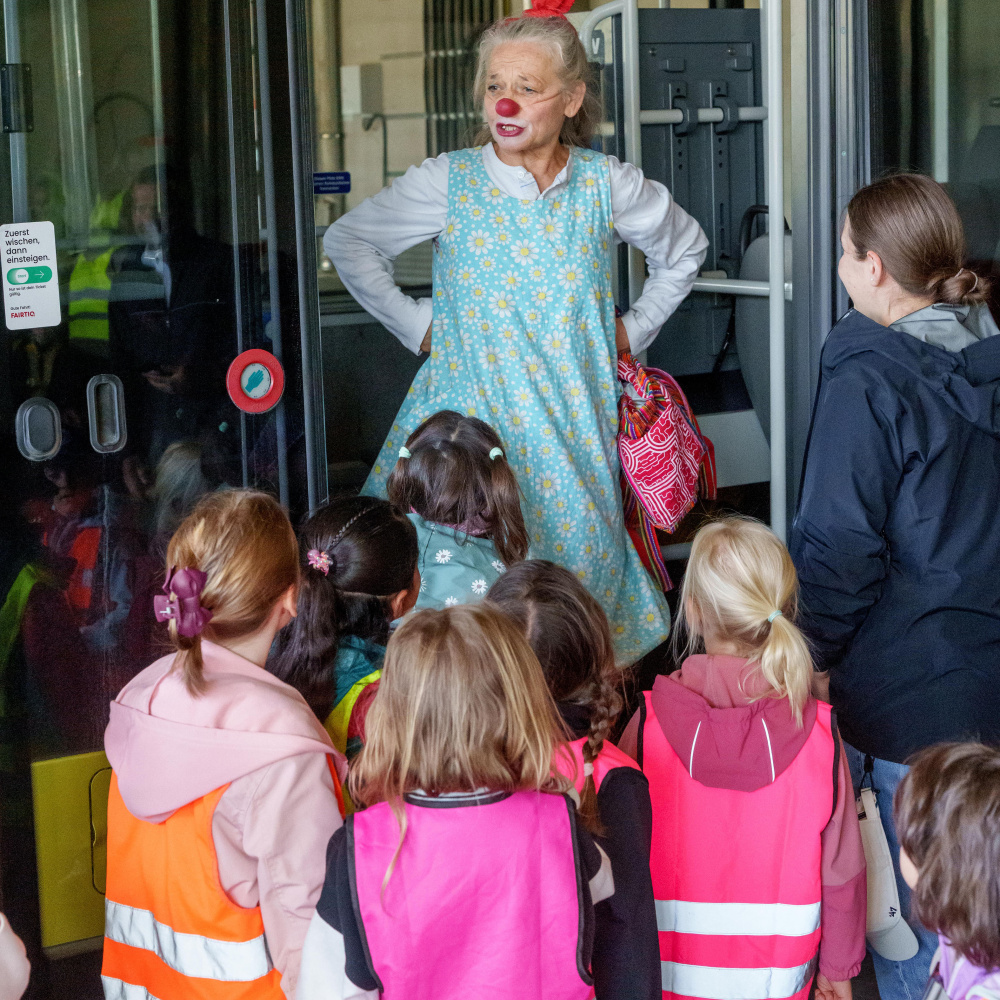 Clownfrau Blombine übt mit Kindern das Busfahren