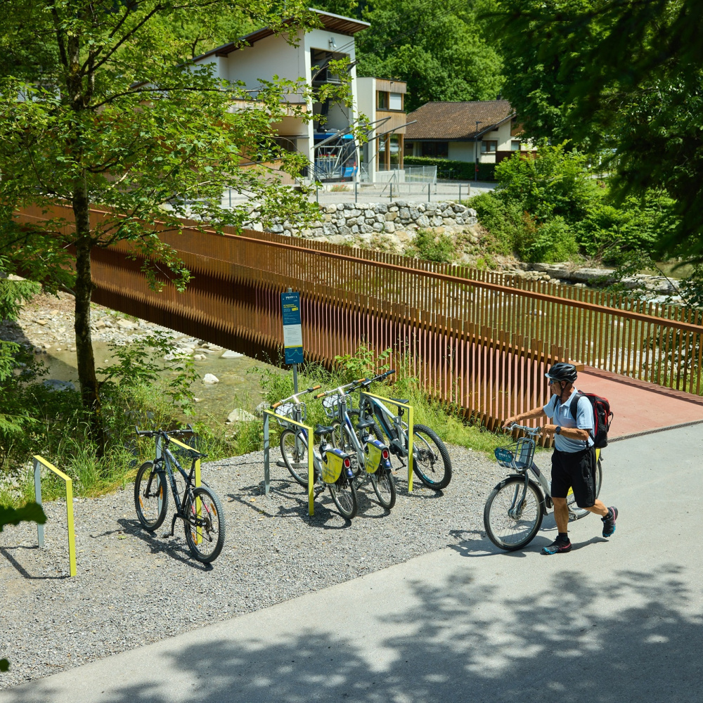 Mann mit VMOBIL Rad bei einer Leihradstation bei der Karren Talstation
