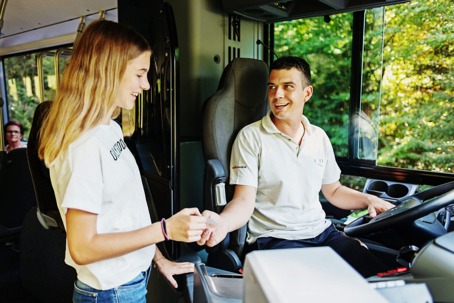 Fahrgast in Interaktion mit dem Busfahrer