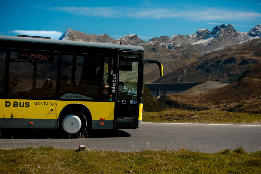 Fahrender Bus vor Bergpanorama
