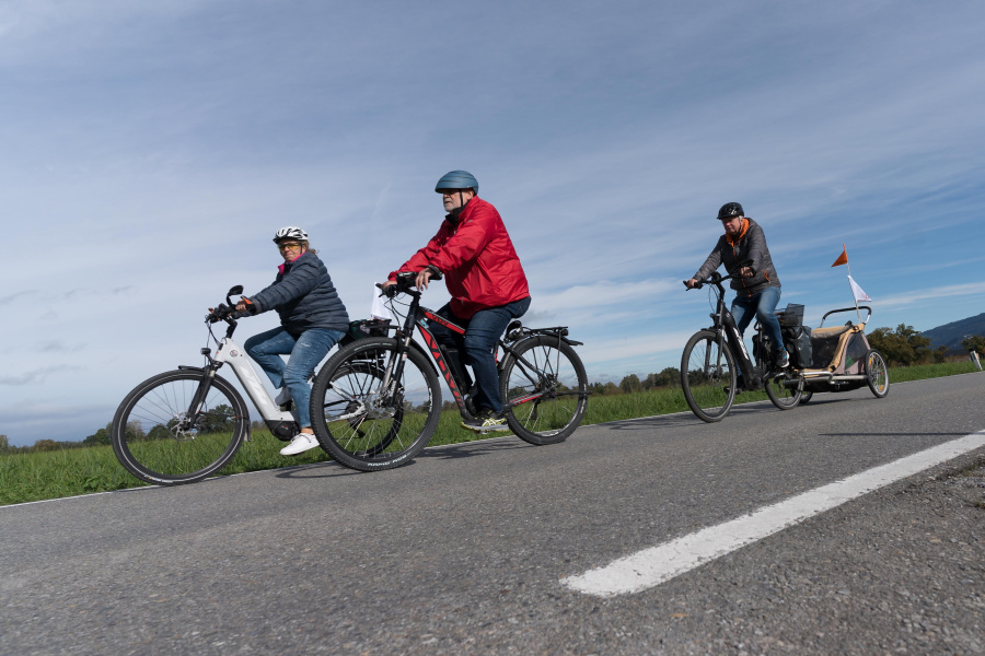 Menschen auf Fahrrädern unterwegs auf den autofreien Straßen im Ried bei schönem Herbstwetter