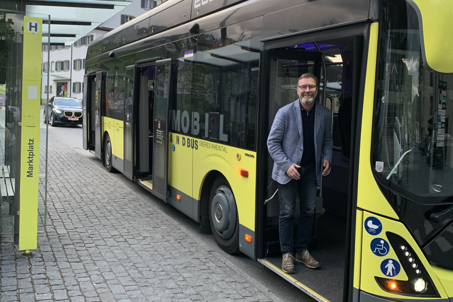 Norbert Wanker steht in der vorderen Bus-Einstiegstüre und lächelt in die Kamera