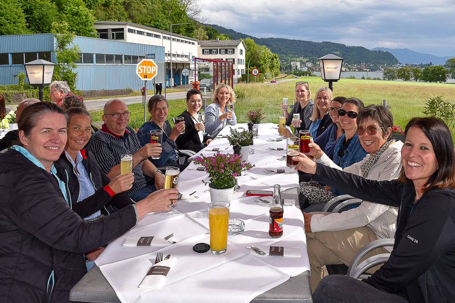 Teilnehmer:innen der Fahrradgenusstour stoßen an einem gedeckten Tisch im Freien gemeinsam an