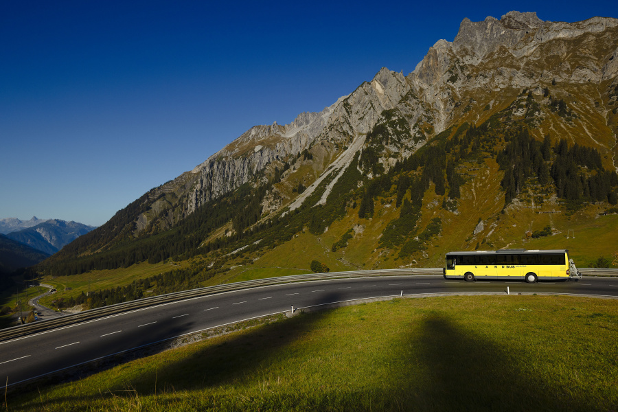 Ein Landbus fährt auf einer Bergstraße. 