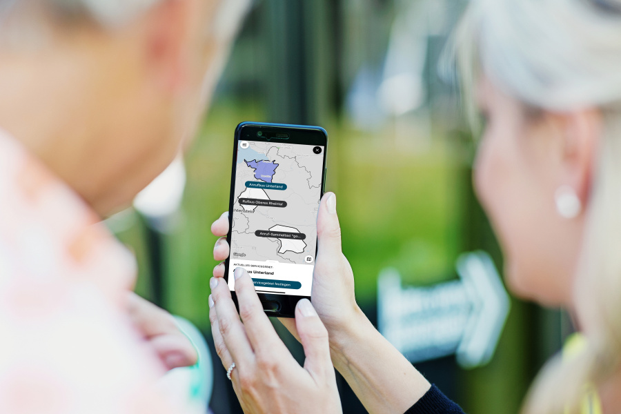 Zwei Personen blicken auf ein Handy mit der VMOBIL On App