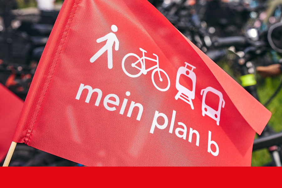 Rote plan b-Fahne im Vordergrund, im Hintergrund unscharf Fahrräder