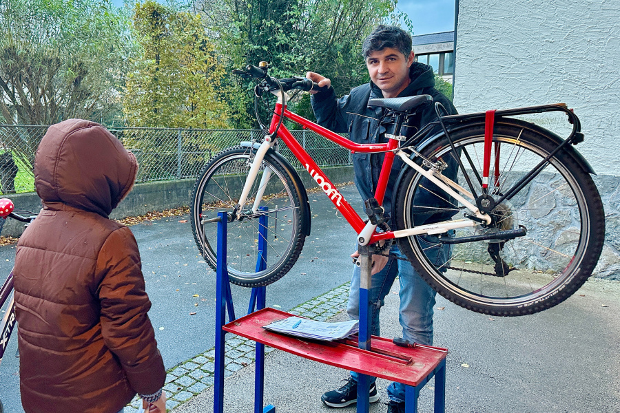 Kind und Mechaniker beim Rad-Reparatur-Kurs