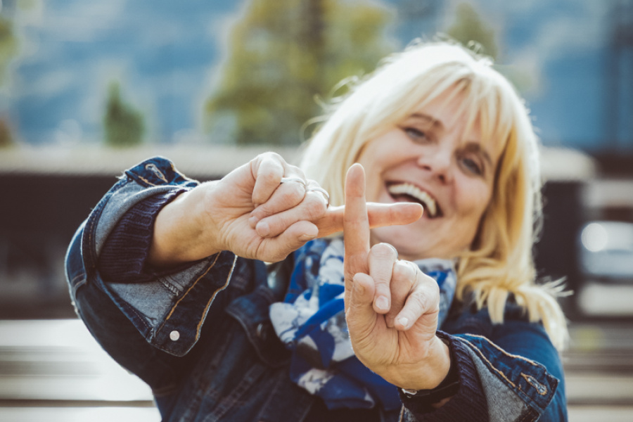 Frau formt mit ihren Zeigefingern ein Plus