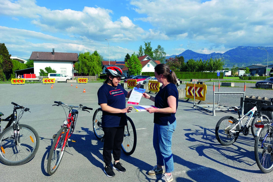 Das Zertifikat zur Teilnahme am Frauenfahrradkurs wird an eine Teilnehmerin übergeben