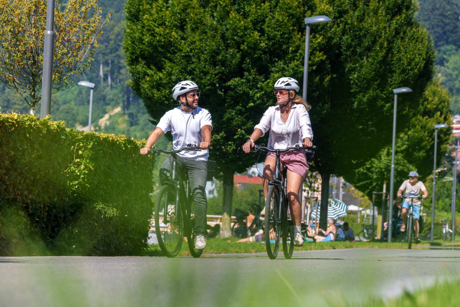 Ein Mann und eine Frau sind gemeinsam mit dem Fahrrad auf dem Radweg unterwegs. 