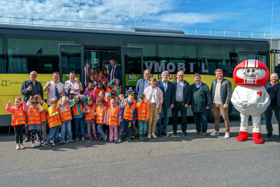 Gruppenfoto mit Gemeinden, Partnern und Kindern vor einem Bus