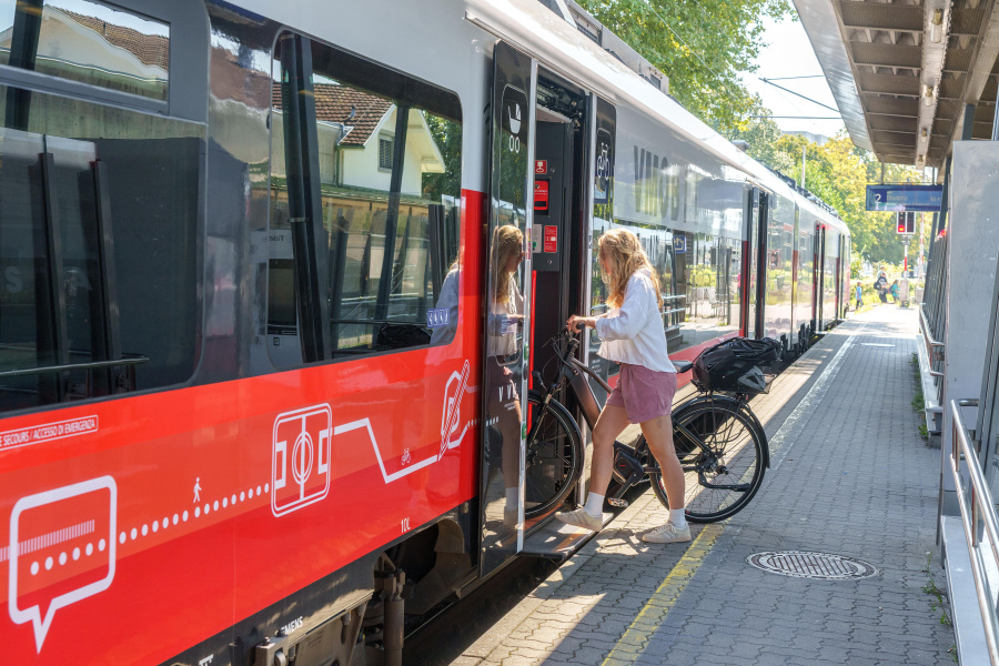 Frau mit Fahrrad zeigt in Nahverkehrszug ein