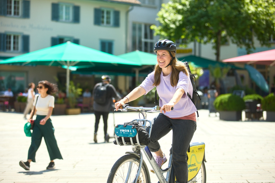 Frau fährt auf einem VMOBIL Rad durch Dornbirn